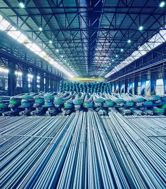 Endüstriyel depoda istiflenmiş uzun inşaat demirleri ve kangal çelik çubuklar.